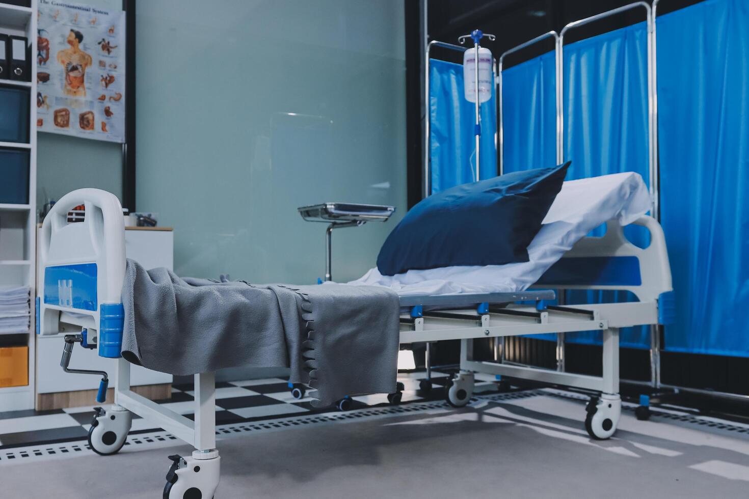 A hospital bed with a blue blanket and pillows photo