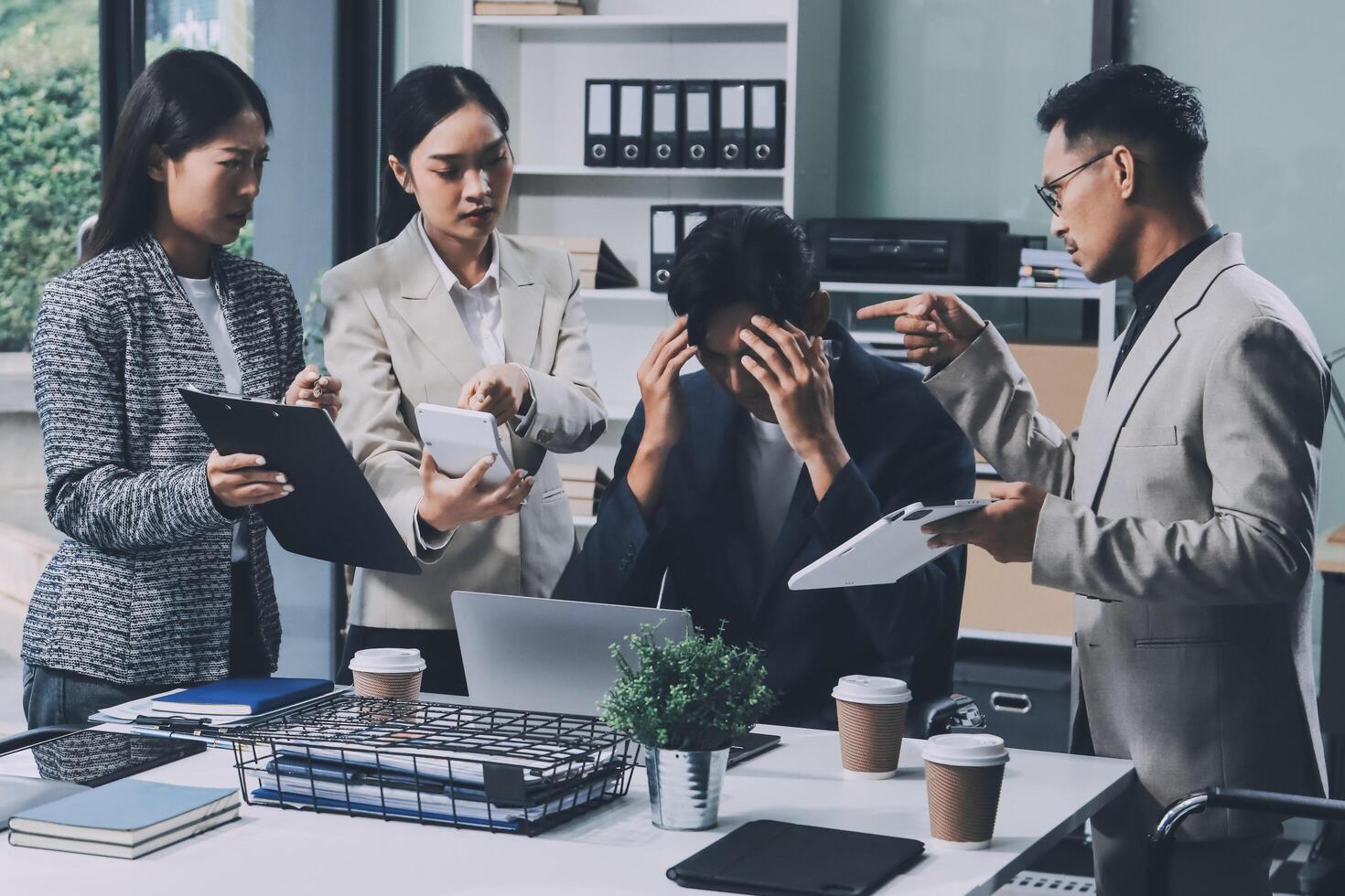 A group of business people standing around a desk photo