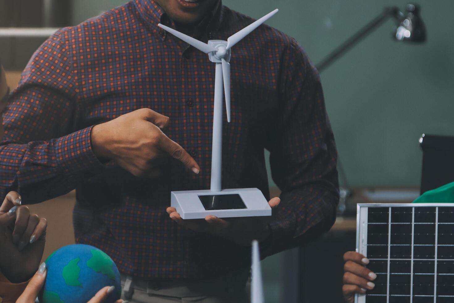 A man holding a wind turbine and a solar panel photo
