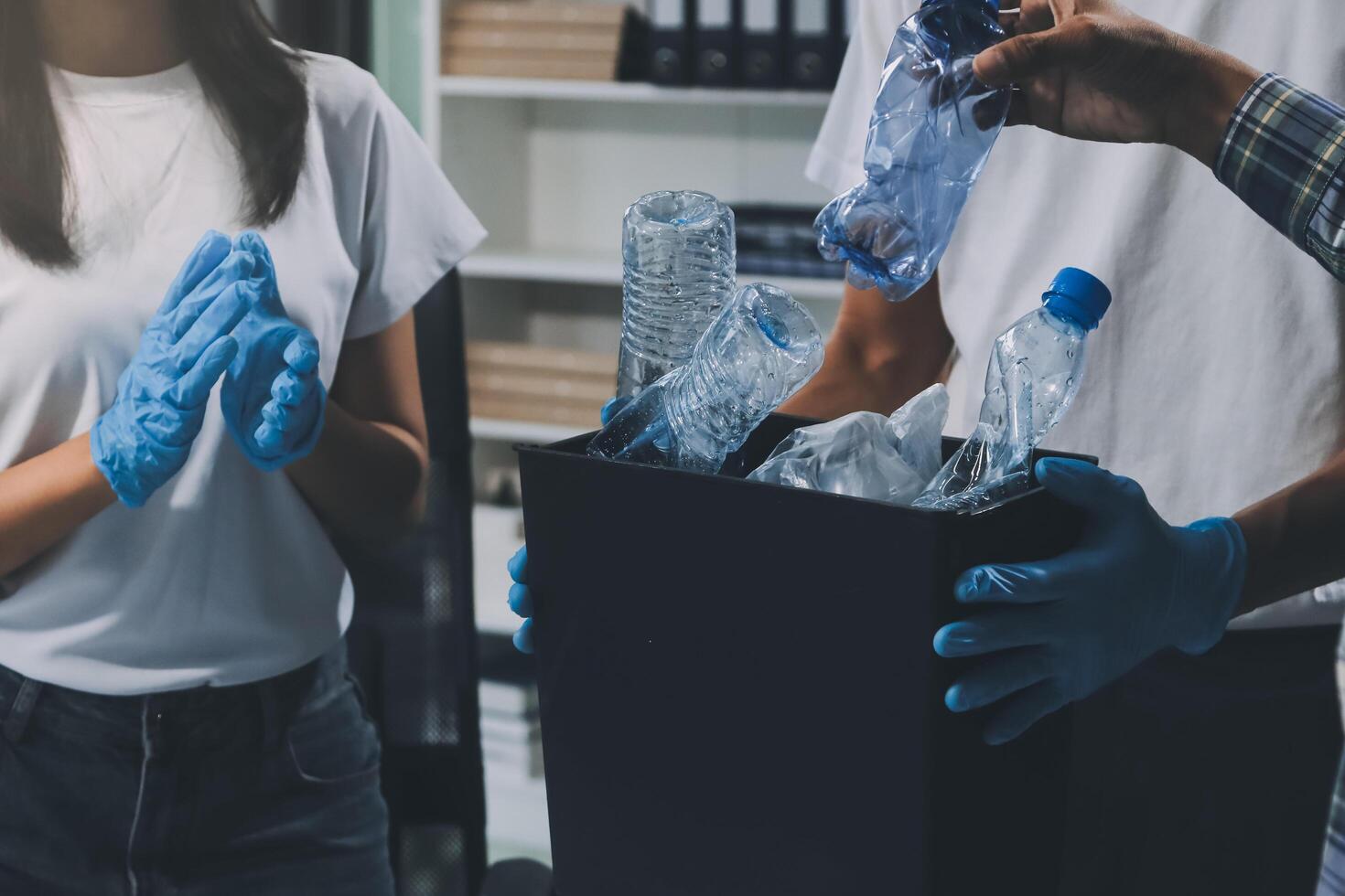 Two people in blue gloves and gloves holding plastic bottles photo
