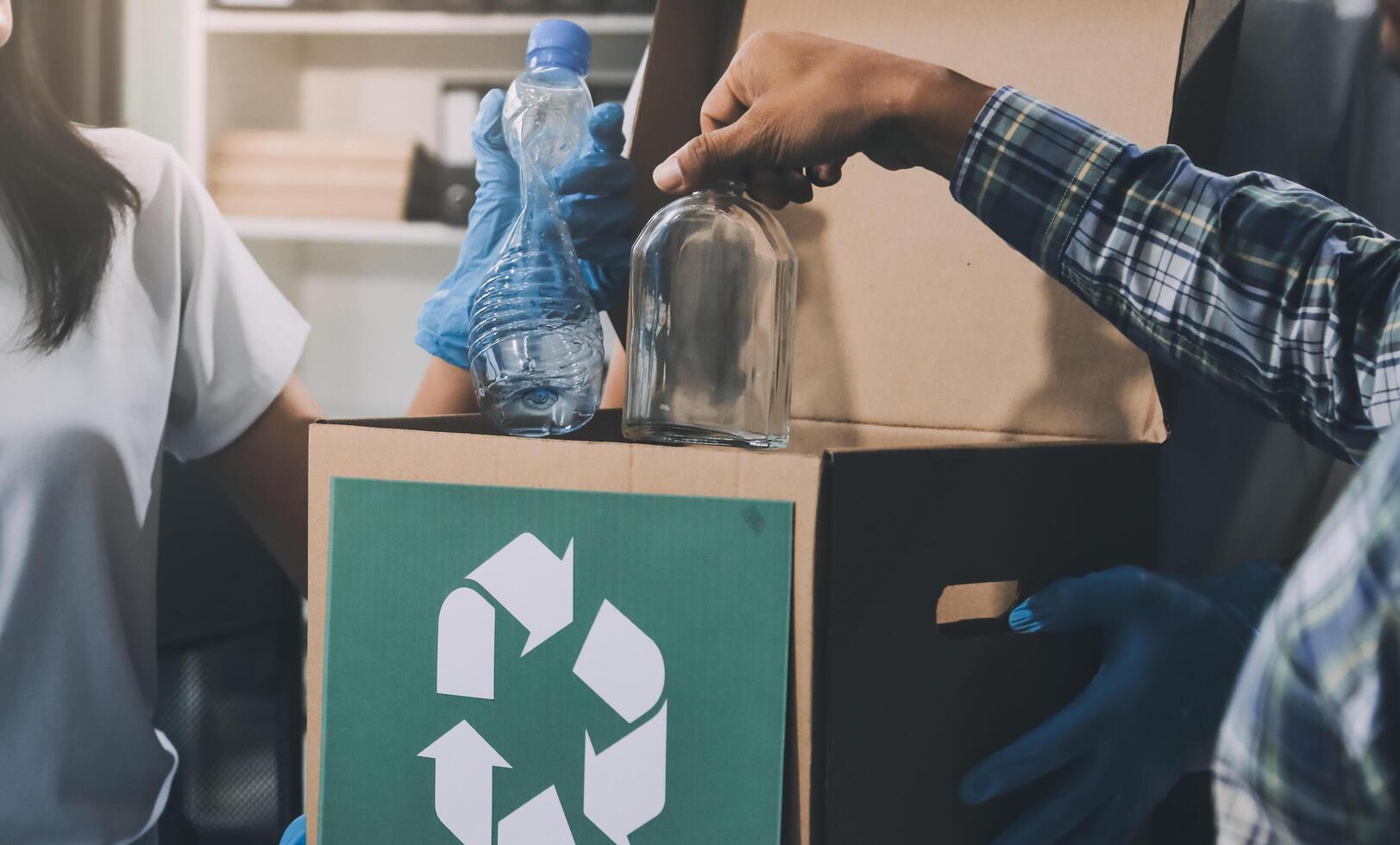 A man and woman are putting a bottle into a box photo