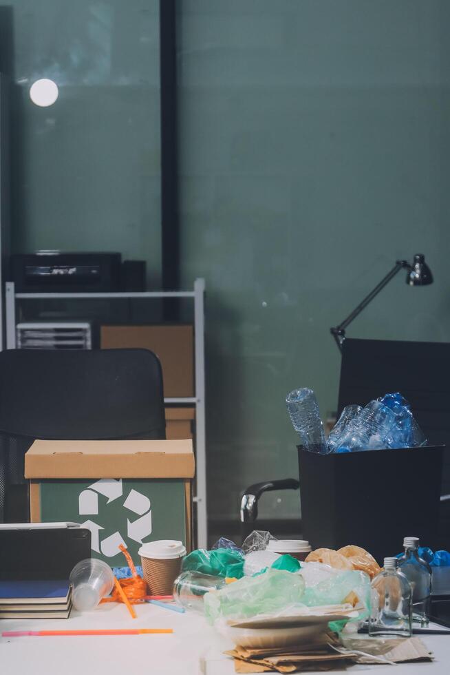 A desk with a laptop, a trash can, and a cup of coffee photo