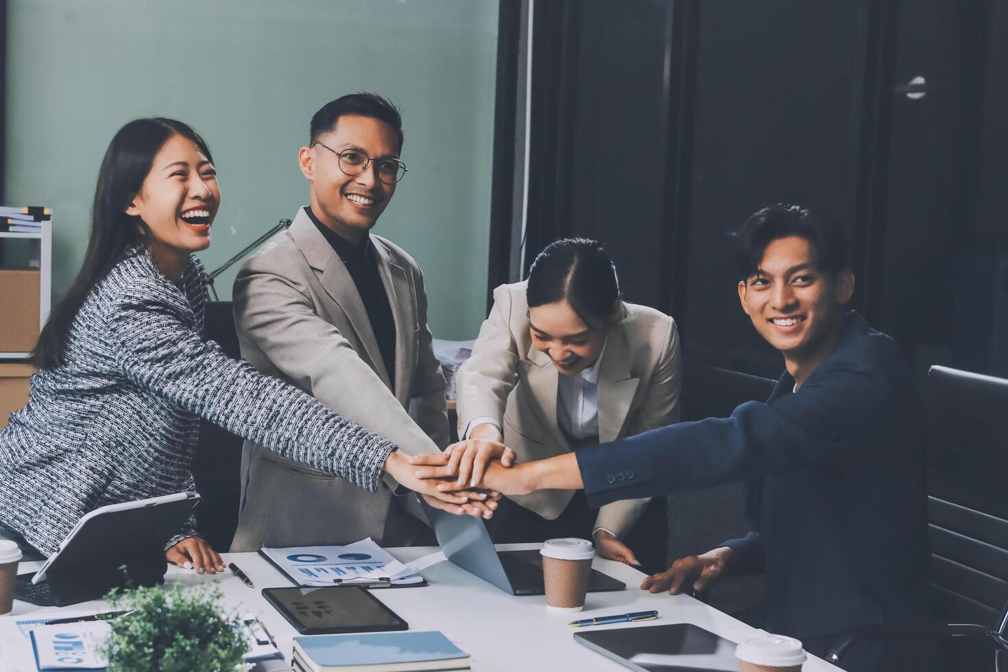 Asian business people holding hands in a meeting photo