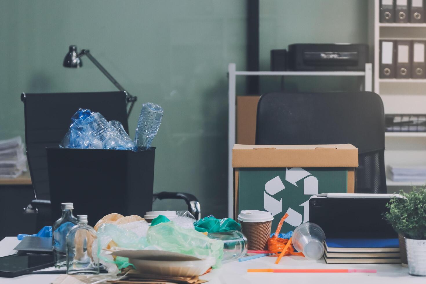 A desk with a laptop, trash, and other items photo