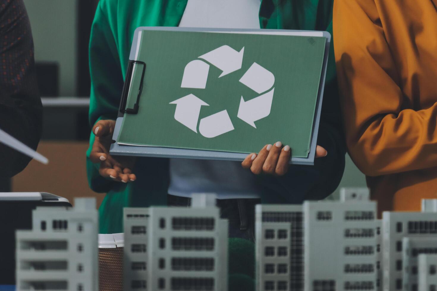 Business people holding a recycling sign in front of a building photo