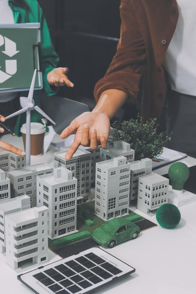 A man and woman are working on a model of a city with a recycling symbol photo