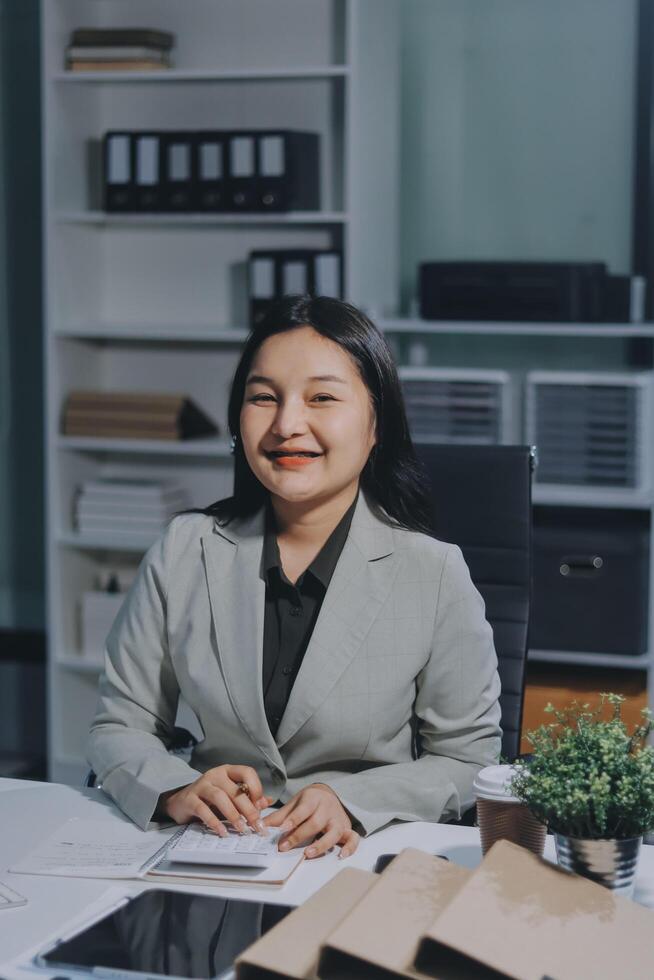 Asian business woman sitting at desk in office photo