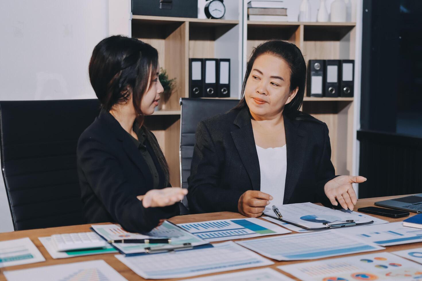 Two businesswomen talking at a desk photo