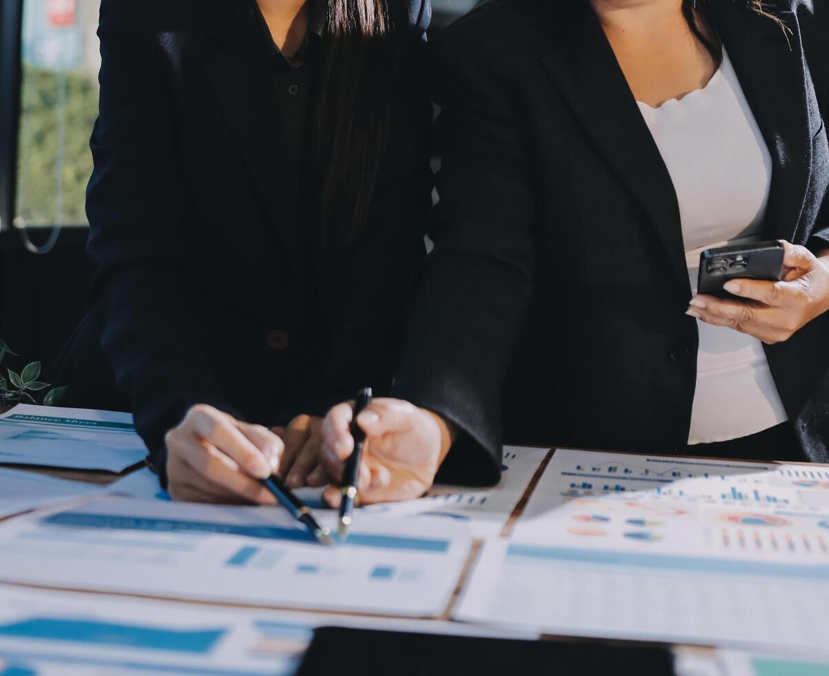 Two business women in suits and ties are working on a document photo