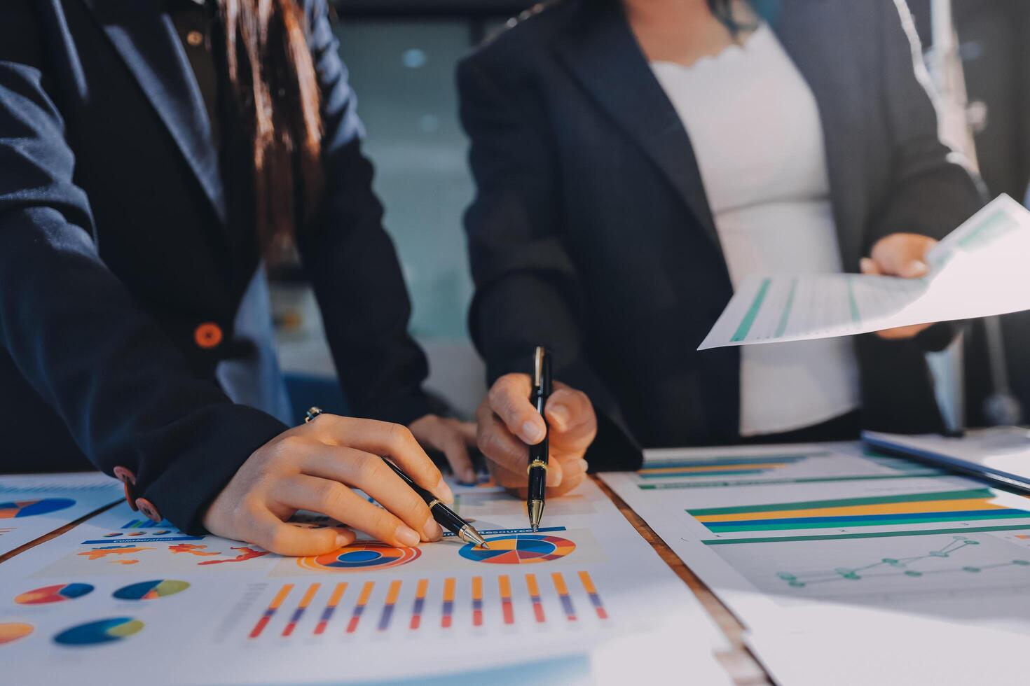 Two business people working on a document with graphs and papers photo