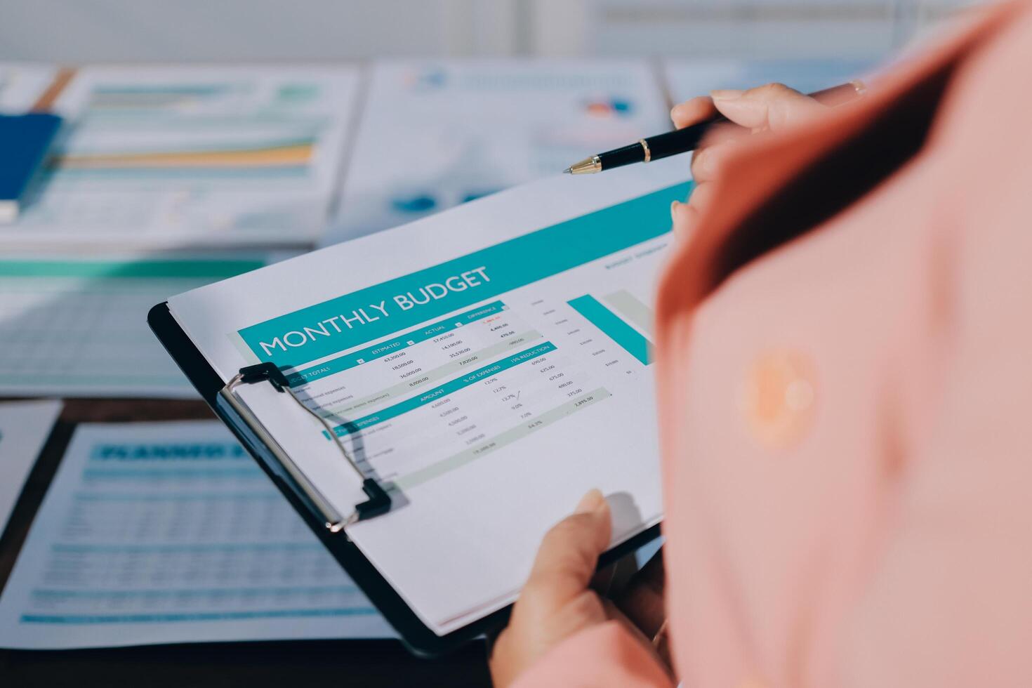 A woman is holding a clipboard with a financial budget on it photo
