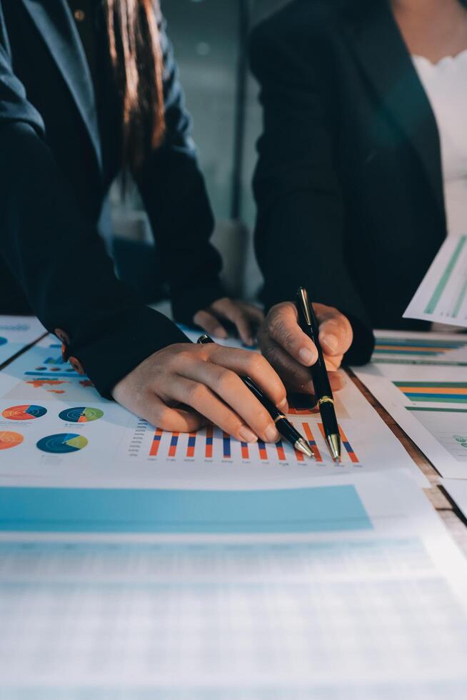 Two business people are working on a document with graphs and papers photo