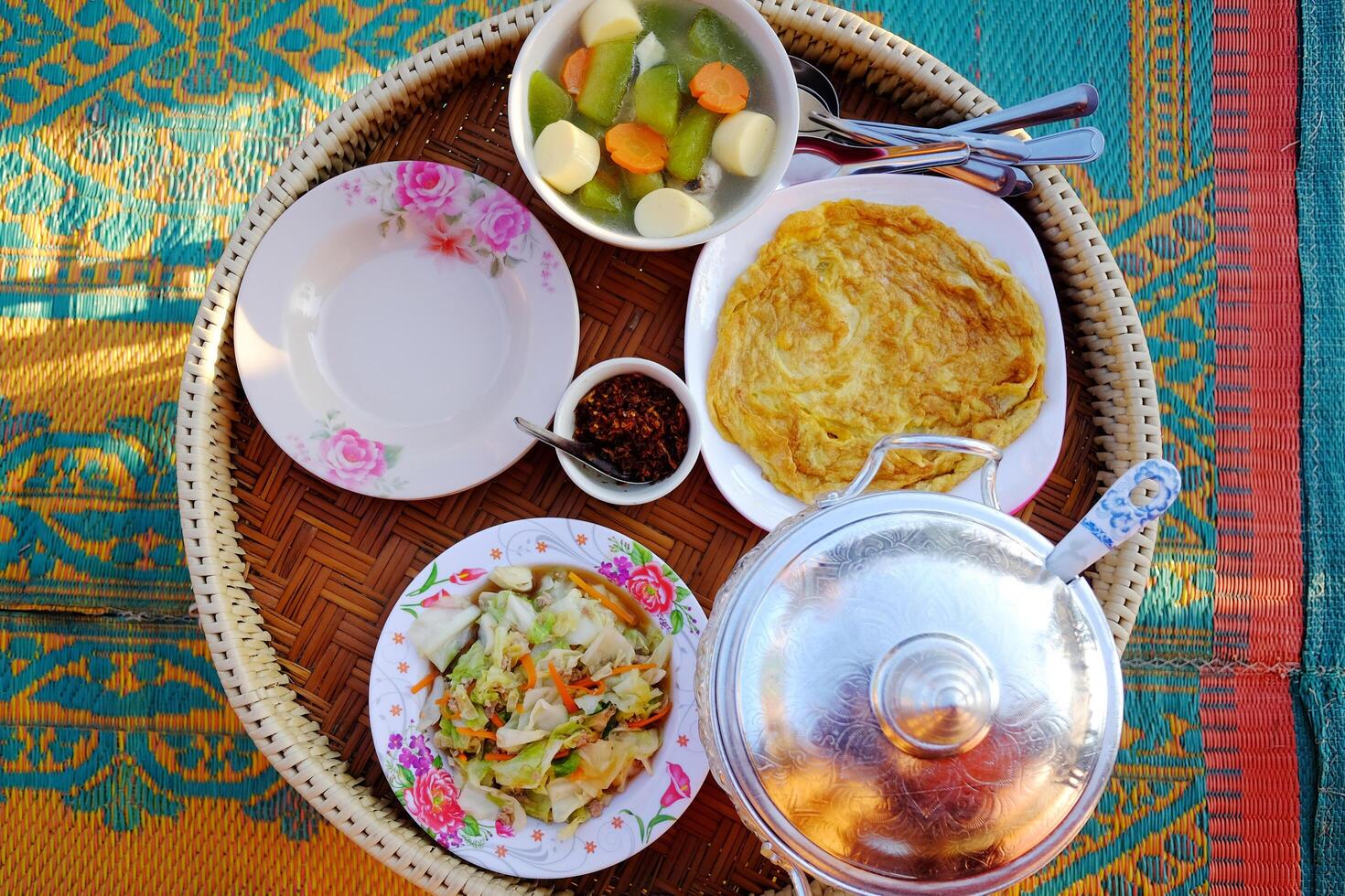 Scrambled egg with stir-fried cabbage and hot steamed rice with Tofu soup and chili sauce on woven basket at homestay. Thai food traditional breakfast or dinner in Thailand photo