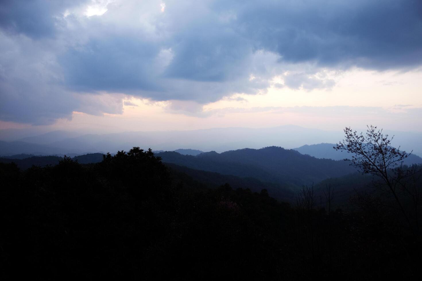 Beautiful sunset and silhouette on the valley mountain with dark cloud sky in Thailand photo