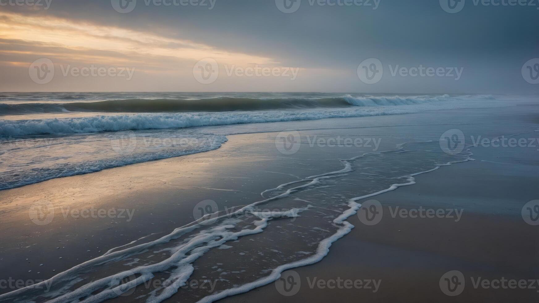 A serene beach scene at dusk, with gentle waves lapping at the shore under a cloudy sky. photo