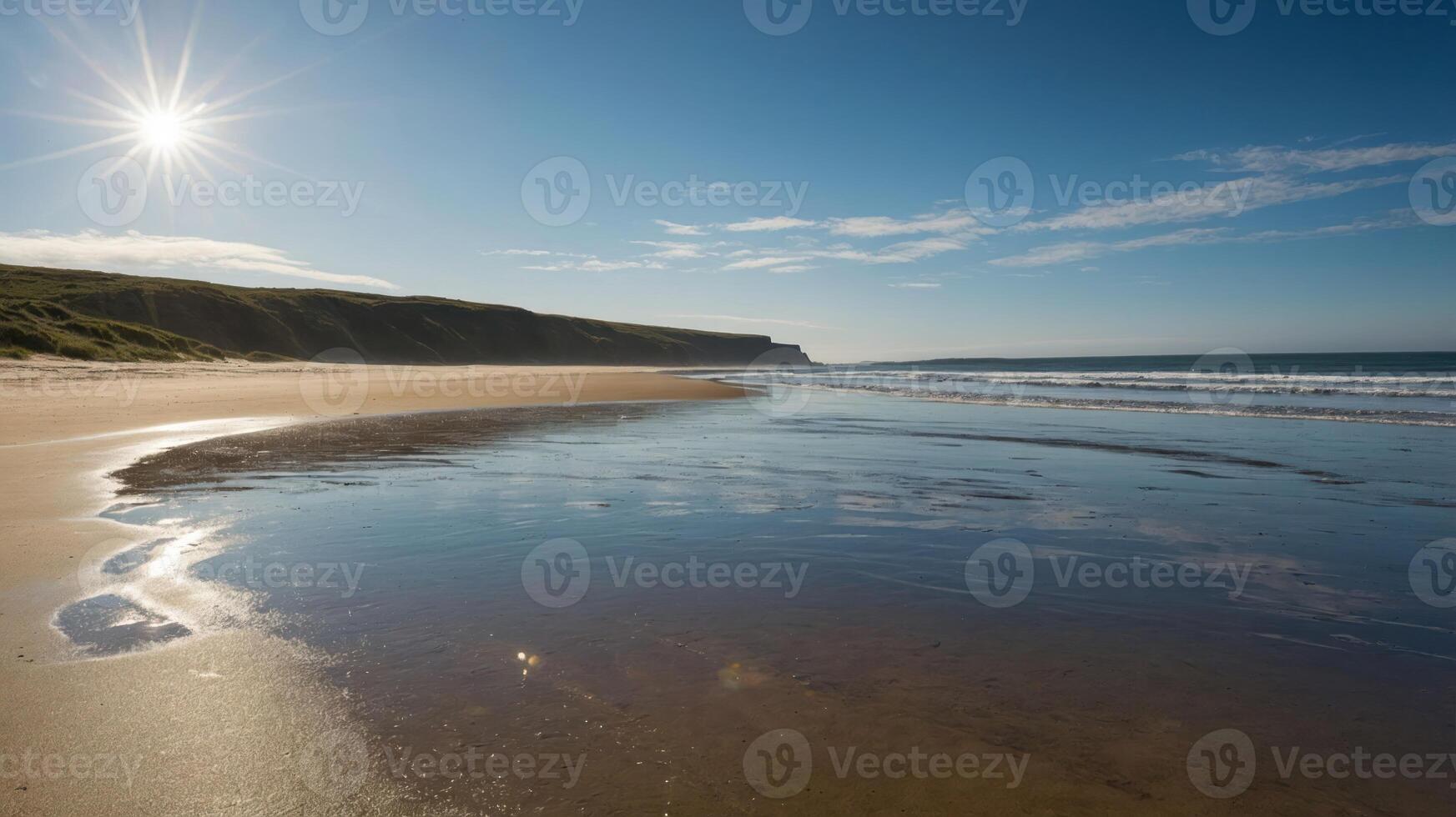 A serene beach scene with gentle waves, sun shining, and a clear sky reflecting on the wet sand. photo