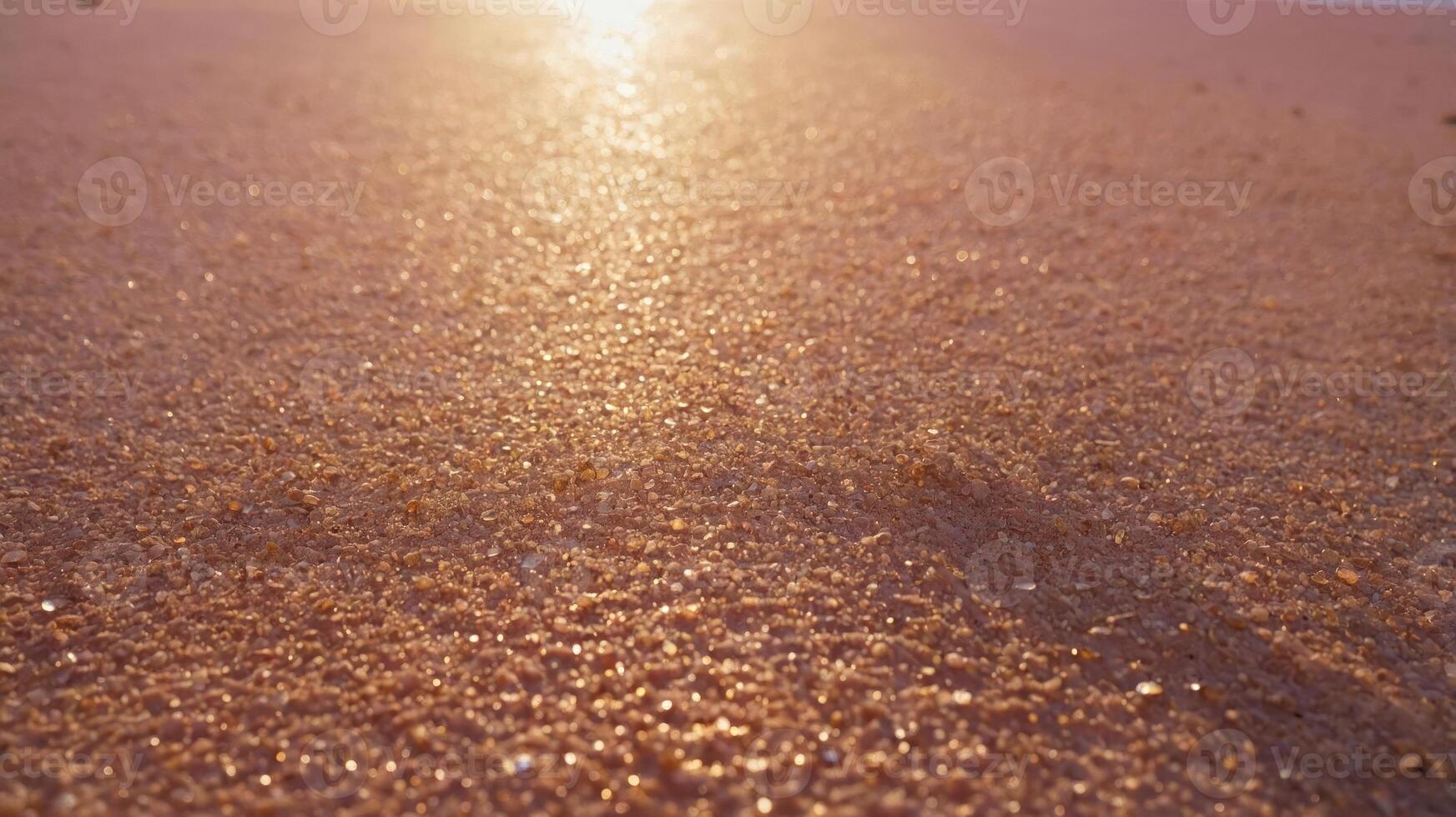 A close-up view of sunlit sand on a beach, capturing the shimmering texture and warm colors. photo