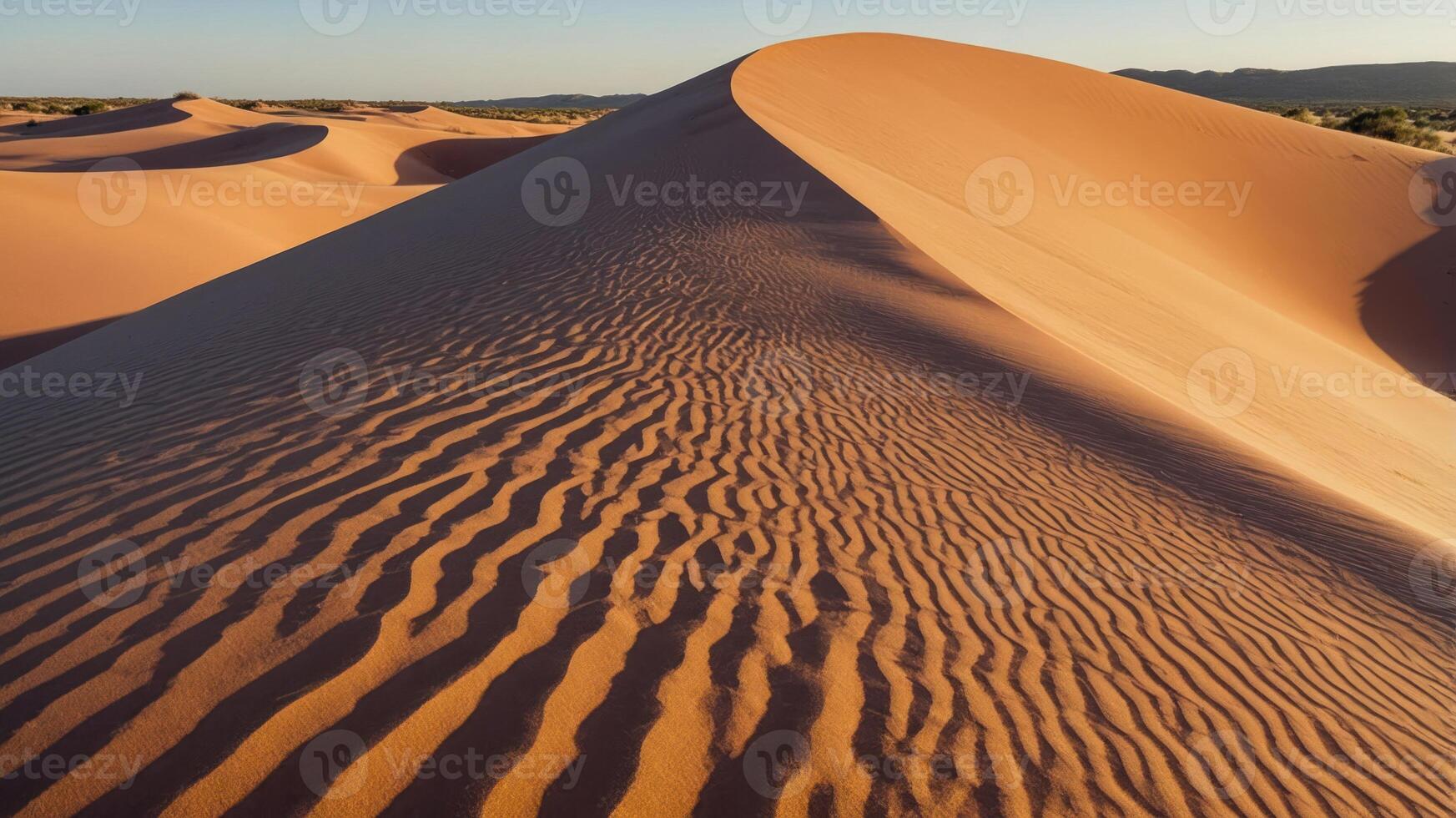 A serene desert landscape featuring rolling sand dunes and textured patterns under warm sunlight. photo