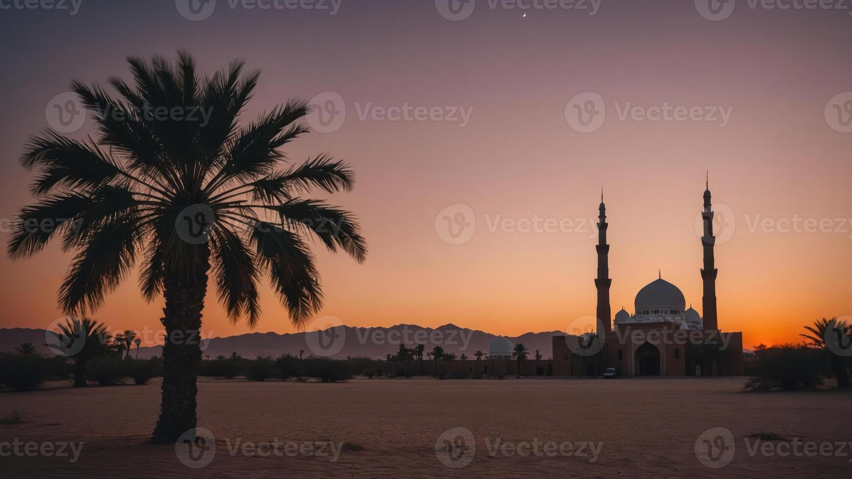A serene sunset view of a mosque surrounded by palm trees and mountains. photo