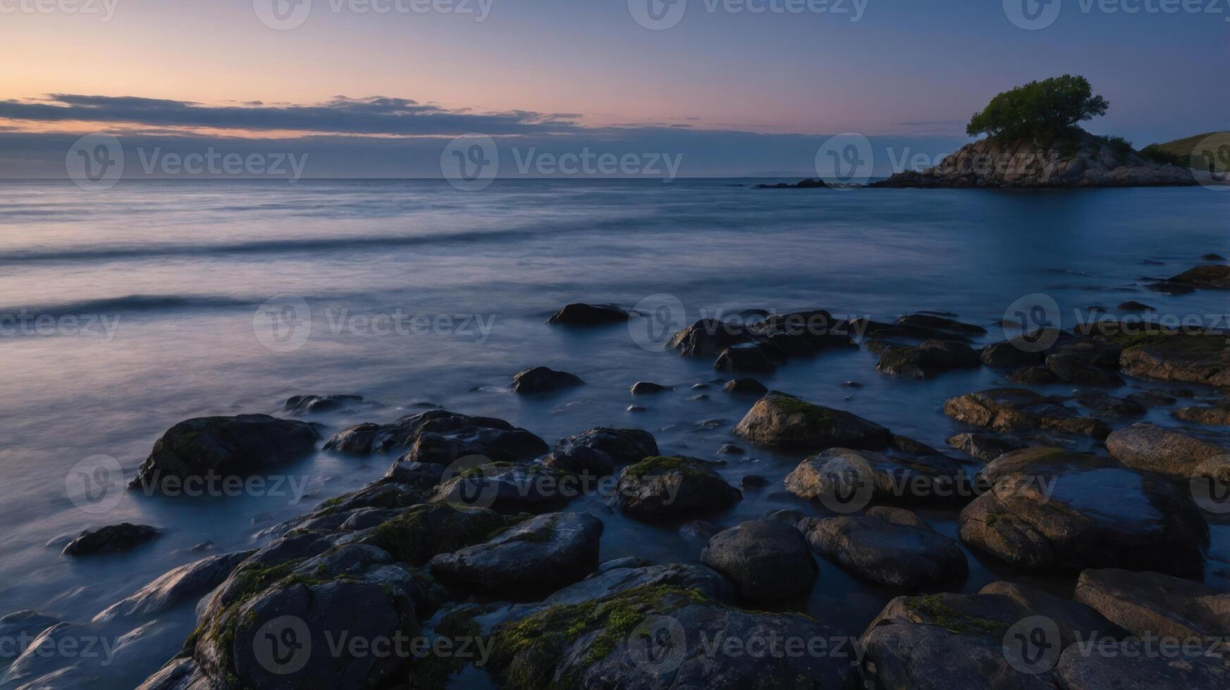 A tranquil coastal scene at sunset with rocks and a solitary tree on a small island. photo