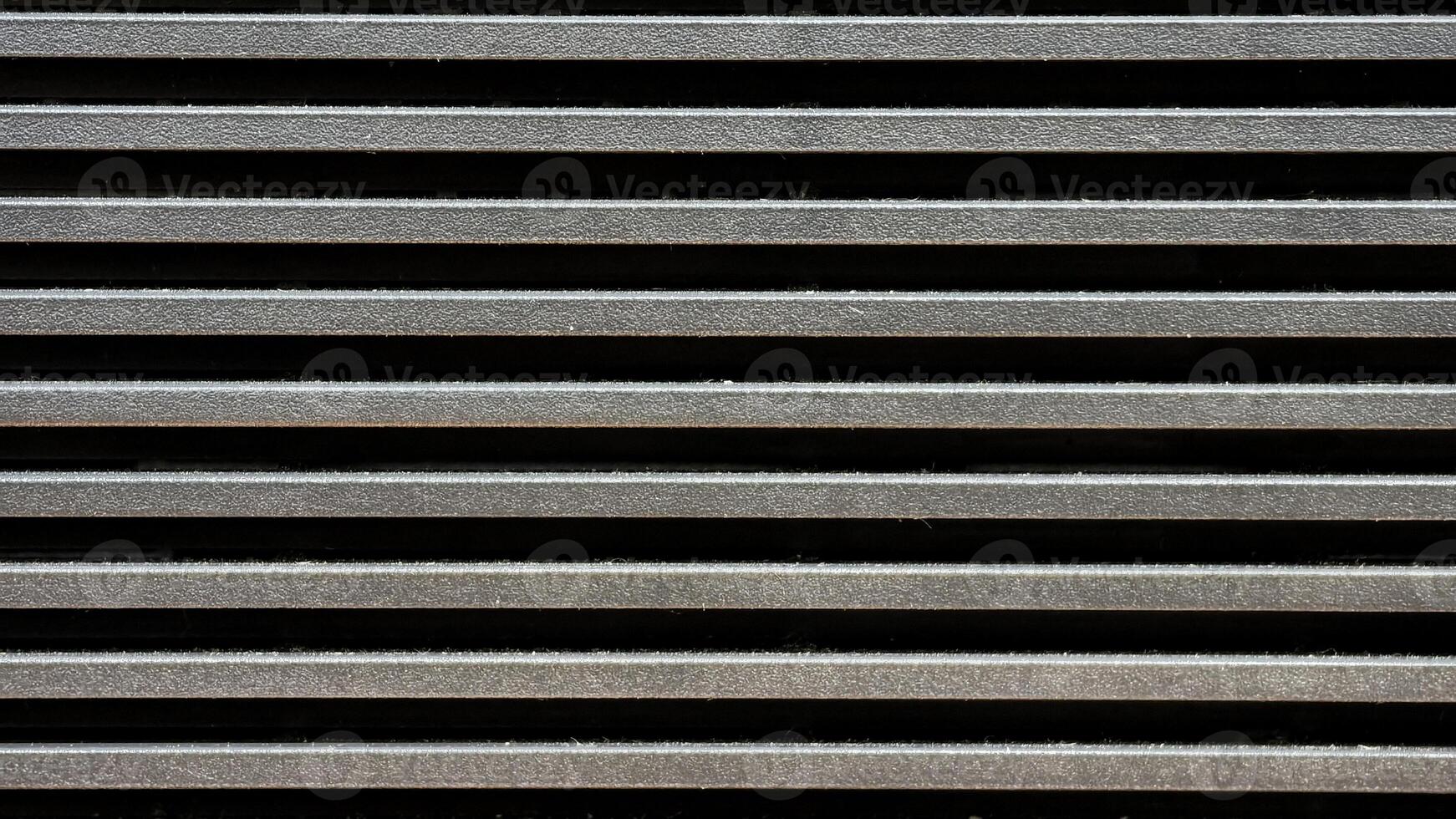 Close up pattern of horizontal metallic ventilation grill slats texture photo