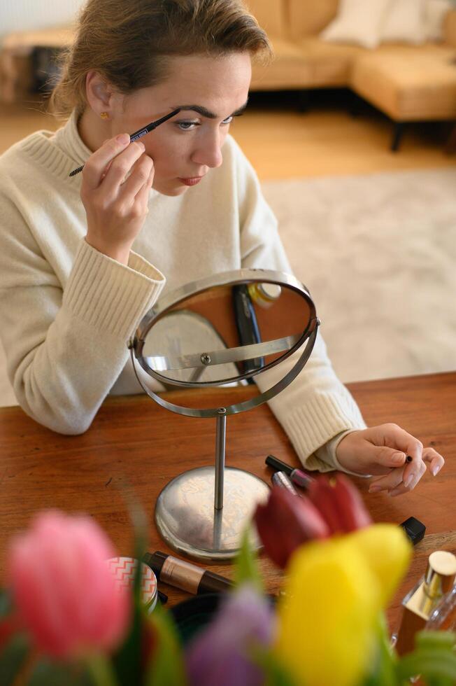 A beauty routine in progress woman applying eyebrow pencil for a natural, defined look. photo