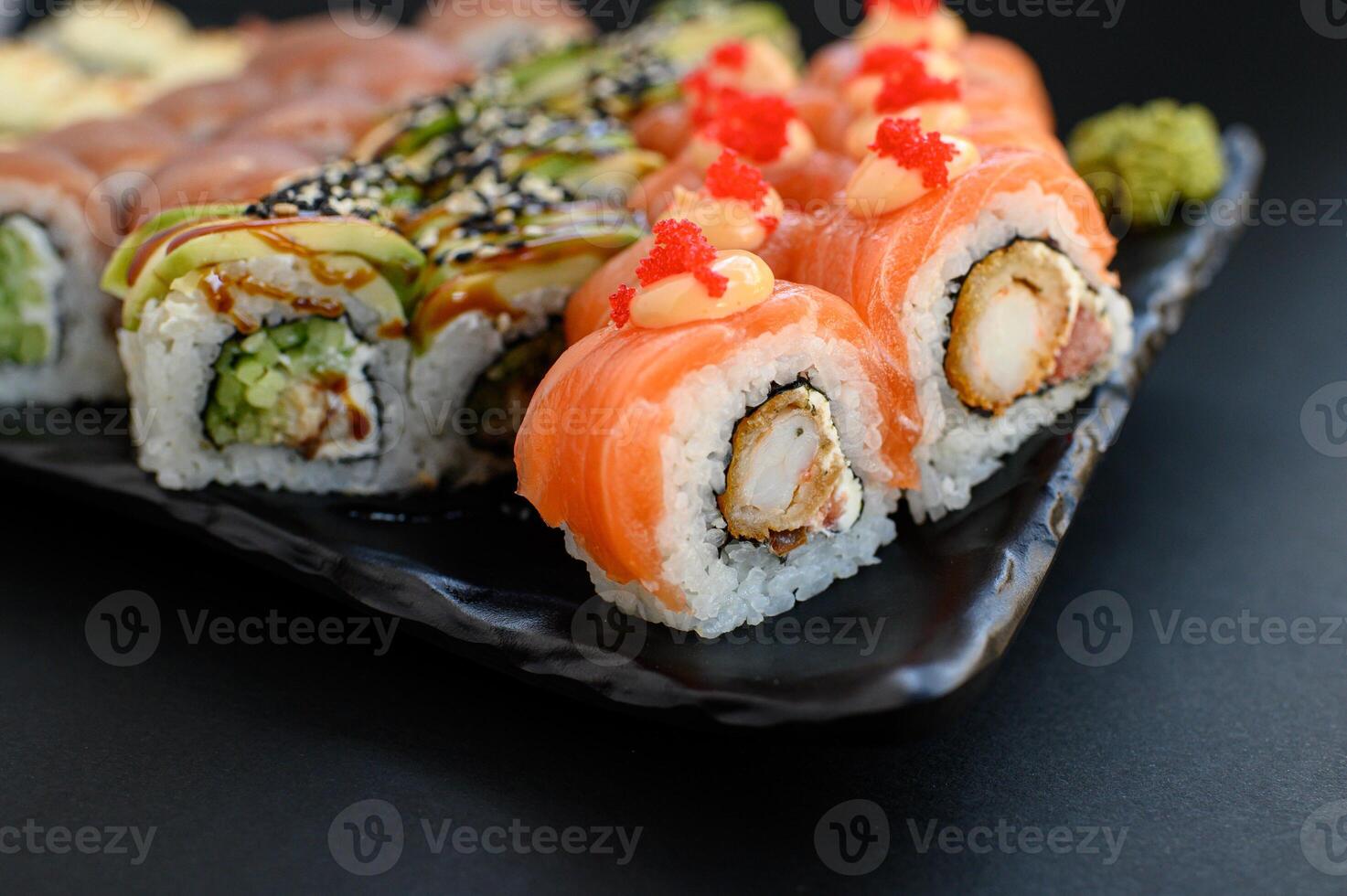 Close up of assorted sushi with vibrant ingredients fresh fish, rice, and seaweed elegantly styled on a dark surface. photo