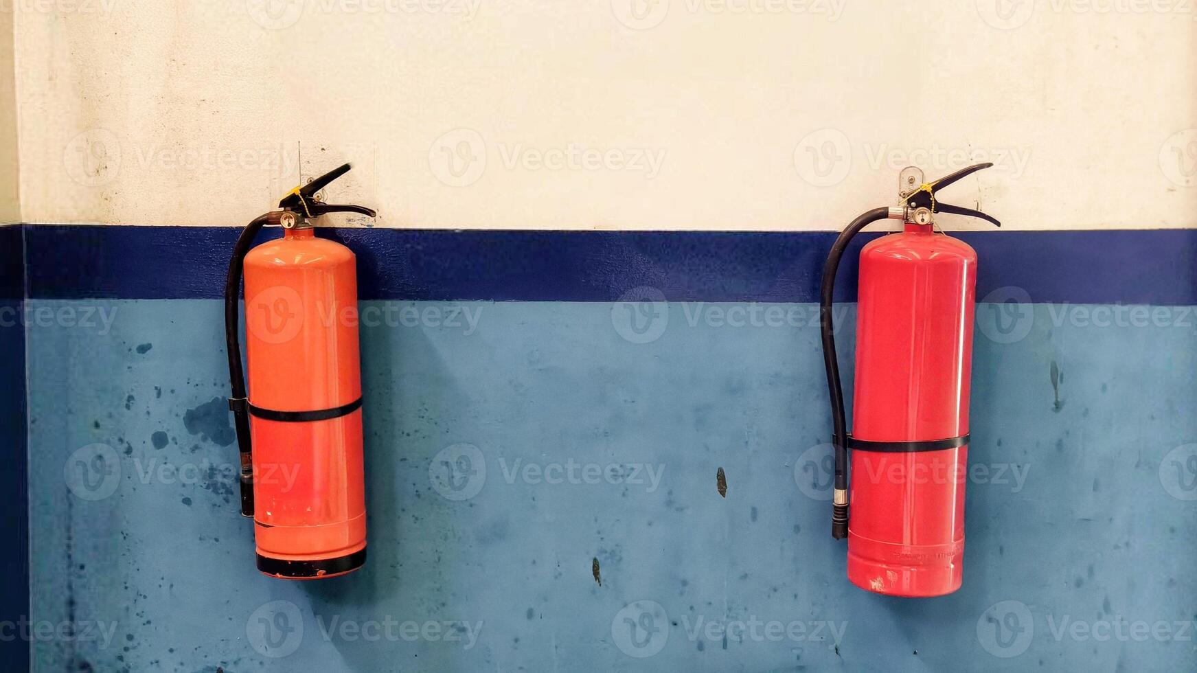 Two Fire Extinguishers Mounted on Industrial Wall for Safety Precaution photo
