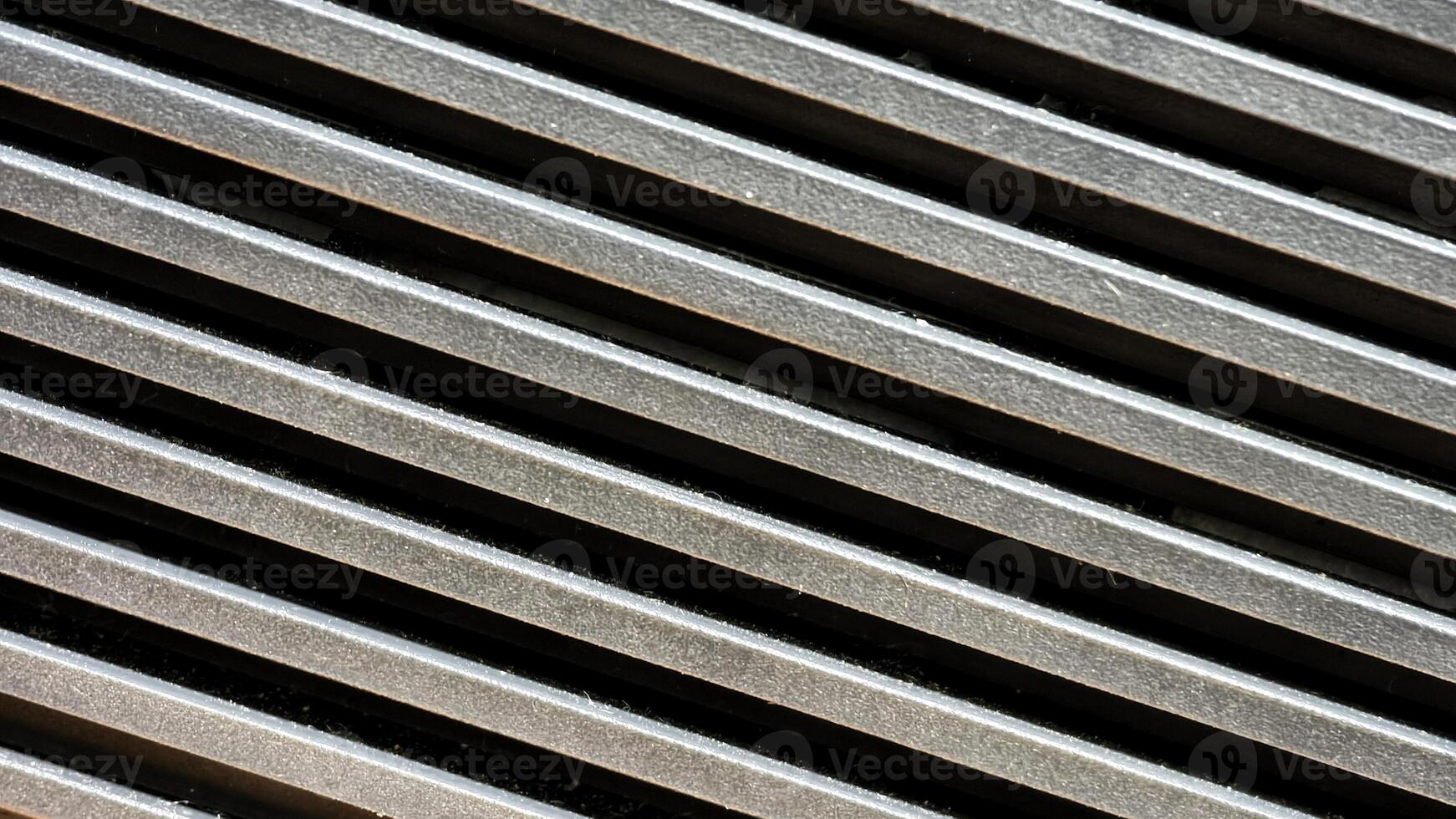 Diagonal Close-Up of Metallic Vent Grille with Strong Contrast and Texture photo