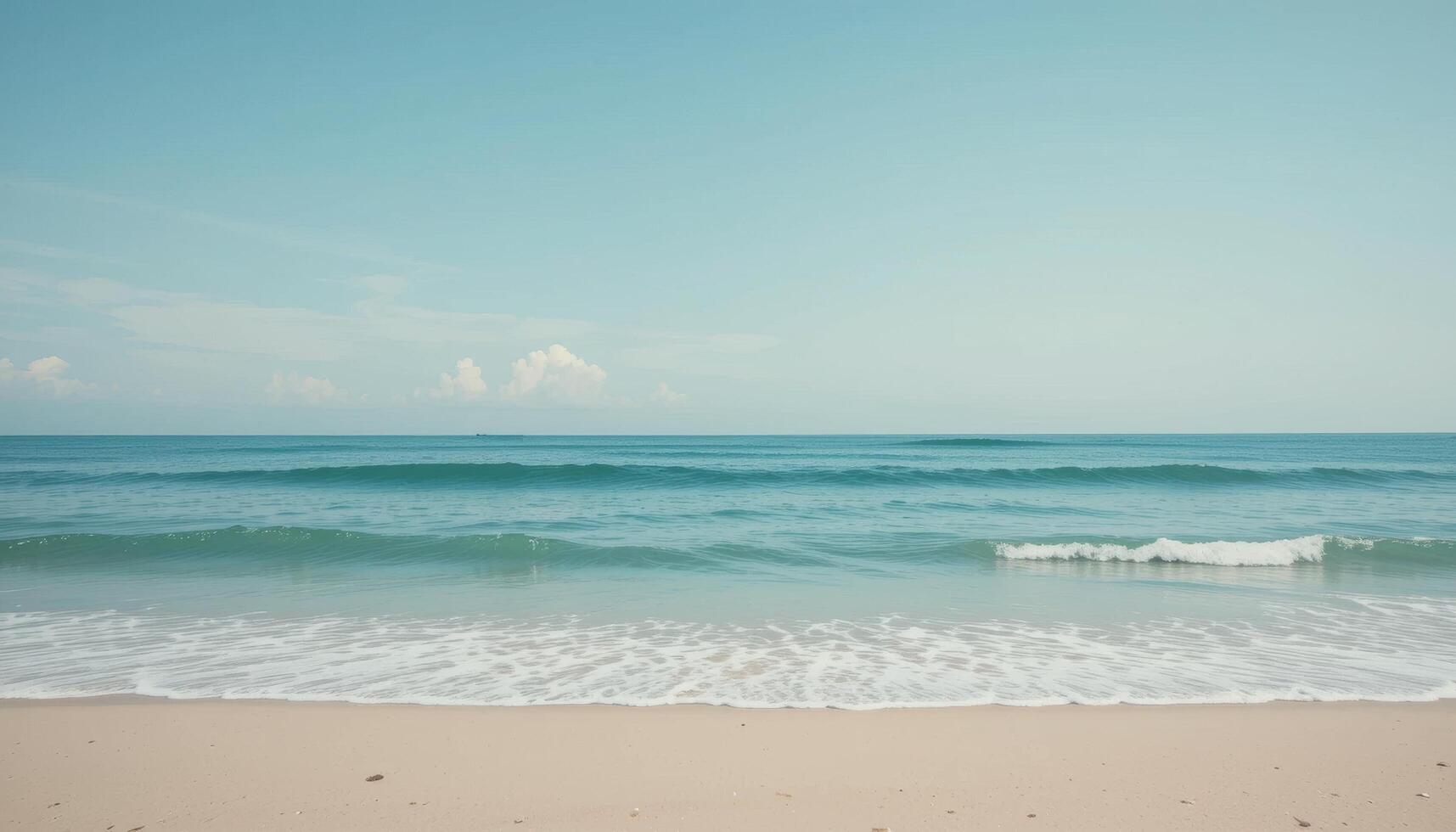 Serene Ocean Waves Gently Lapping on Sandy Beach Under Clear Sky photo