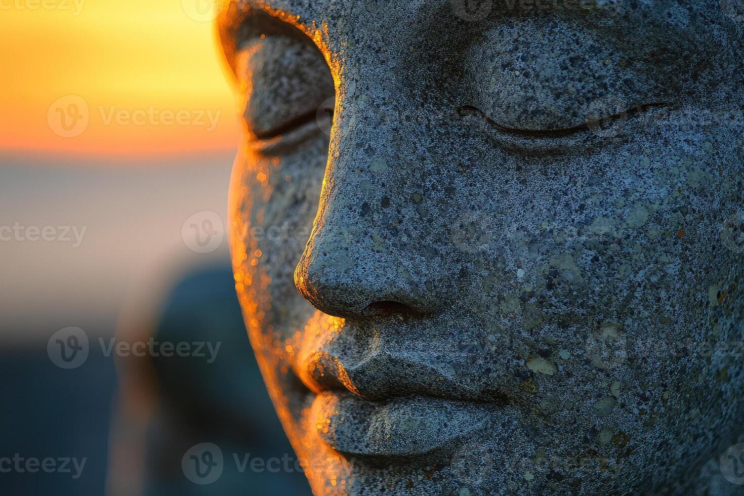 A stone statue of a buddha with its eyes closed photo