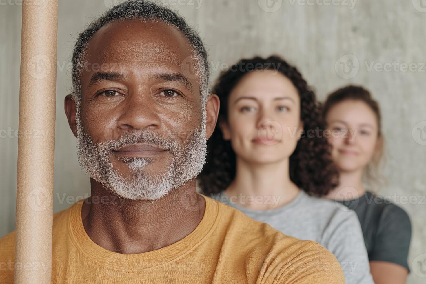 Group of diverse adults standing in a line with focus on african mature man photo