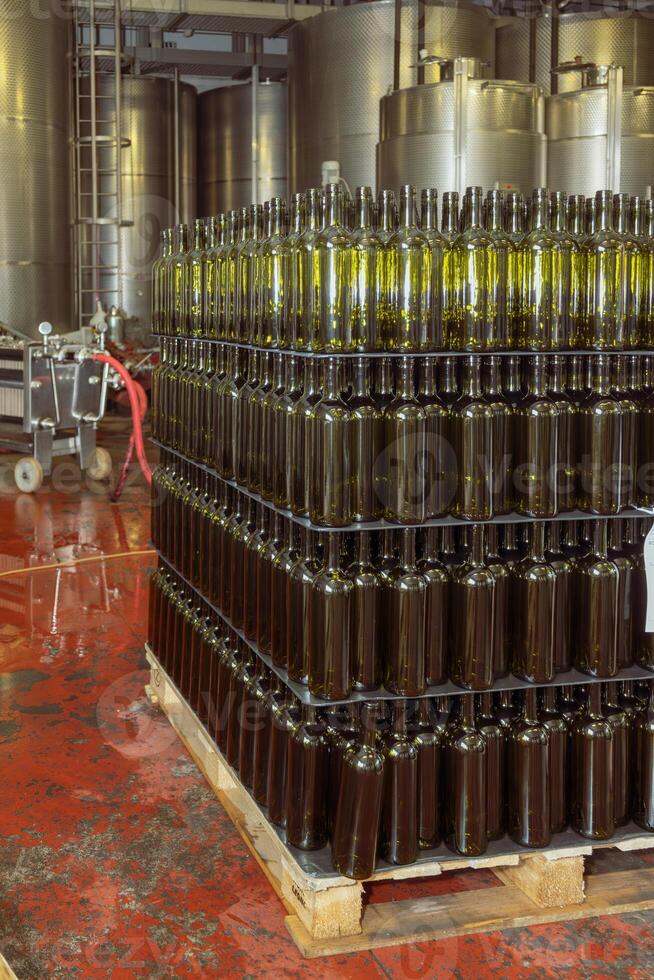 Wine bottles stacked on pallet in winery cellar photo