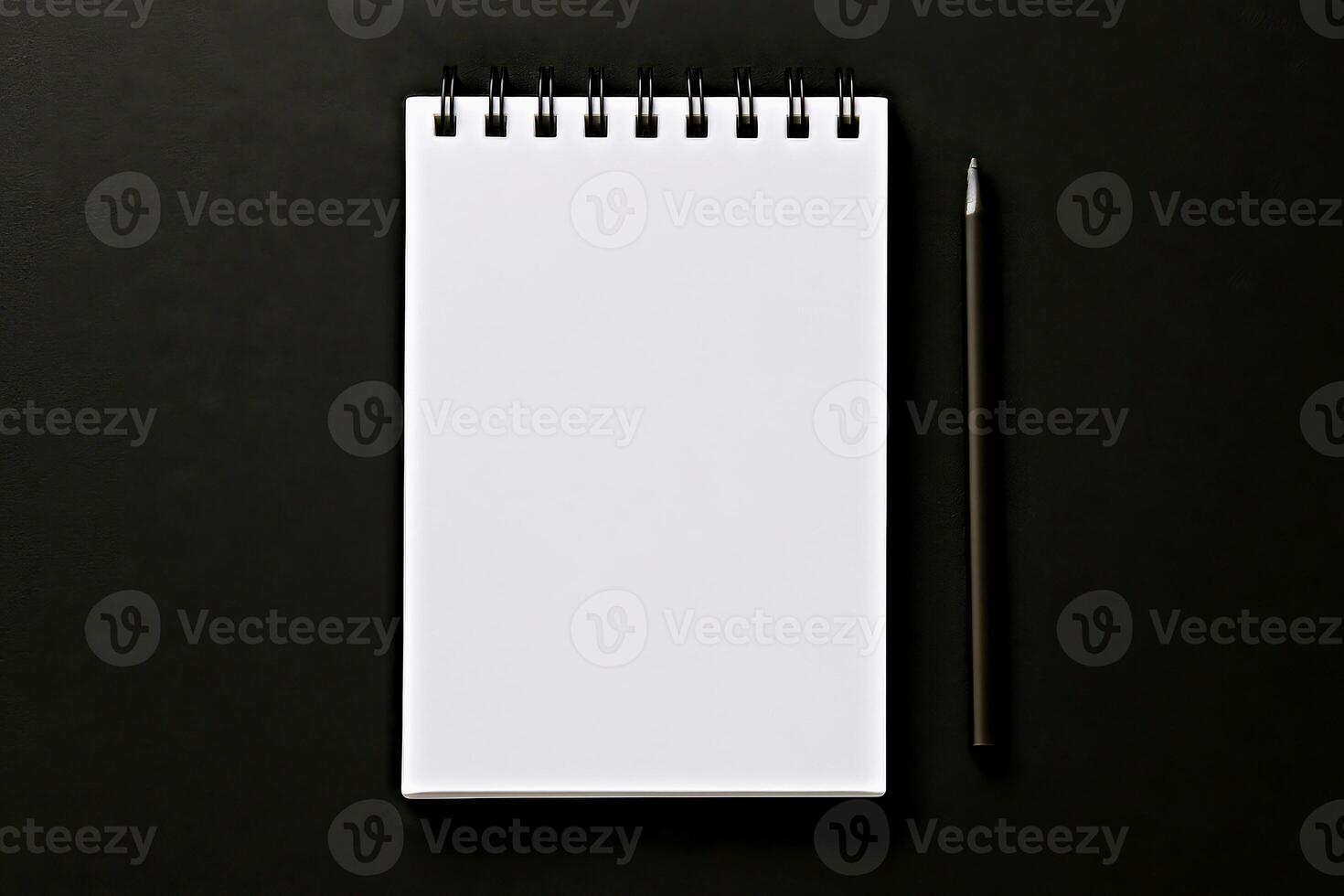 White spiral notepad with black pen on dark background symbolizing planning, writing or business concept photo