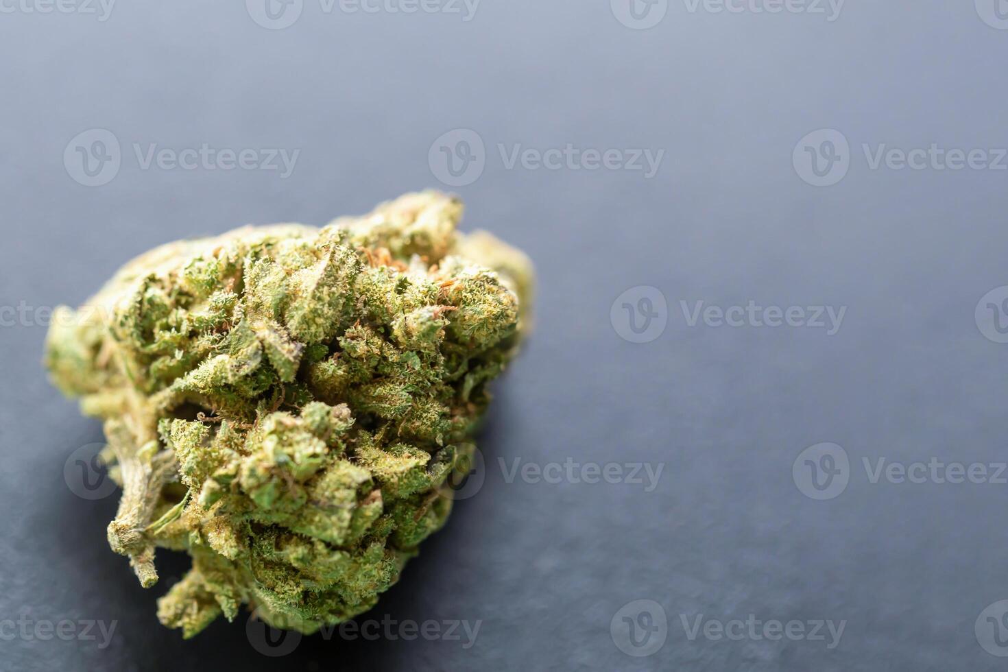Macro shot of cannabis bud on dark background showing detailed texture, trichomes and natural coloration for medical or recreational use. Concept of herbal medicine or CBD. Cannabis flower photo