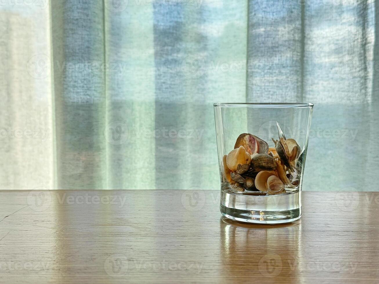 Copyspace with glass of shells on wood table photo