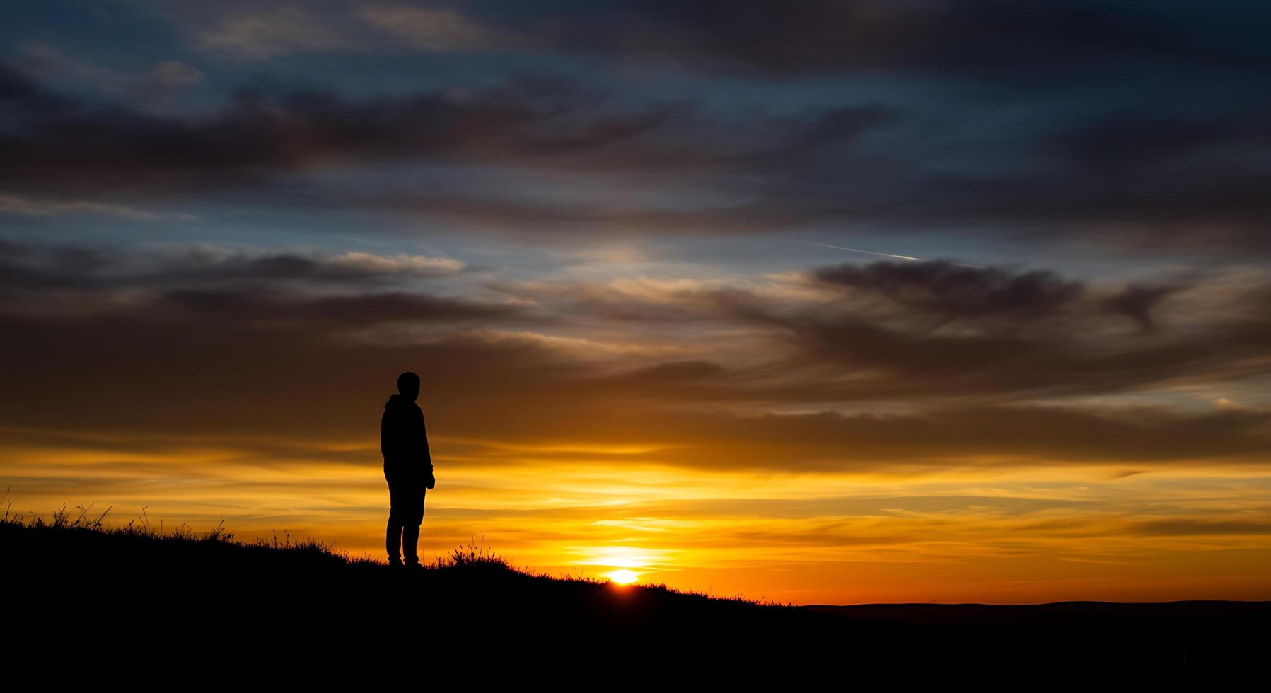Silhouette of a Person at Sunset, Contemplating the Golden Hues of the Evening Sky photo