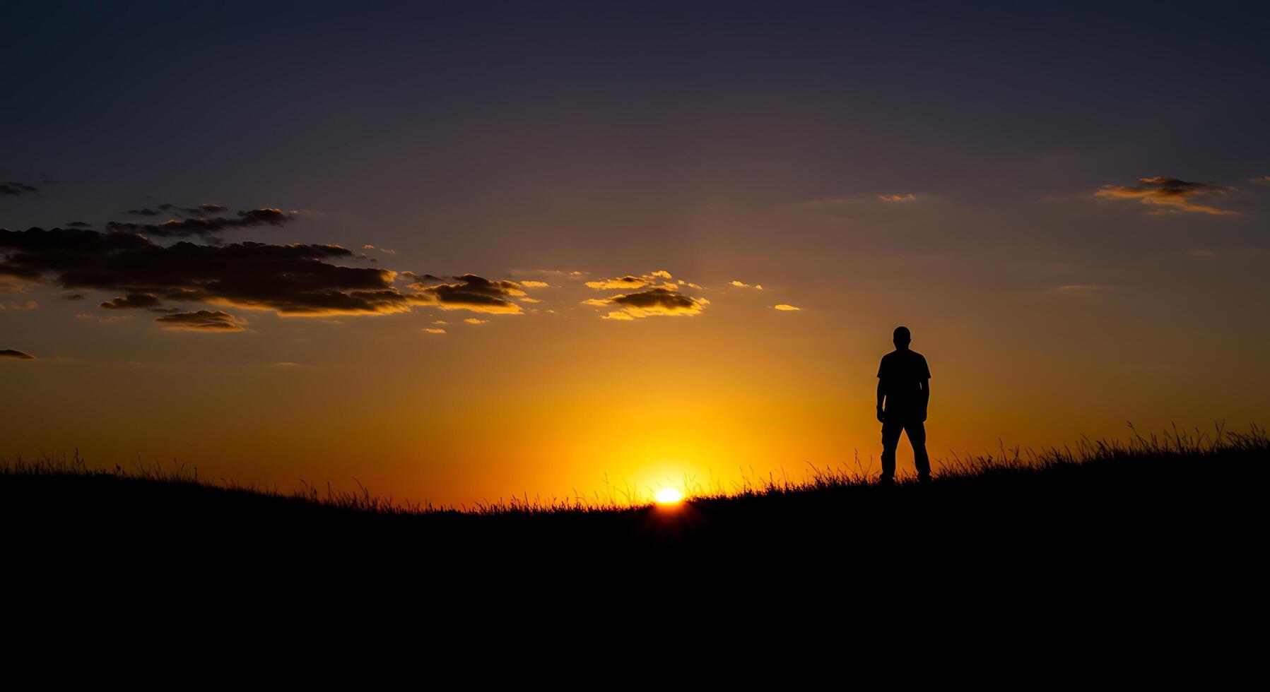 Silhouette of a Man at Sunset Over a Field photo