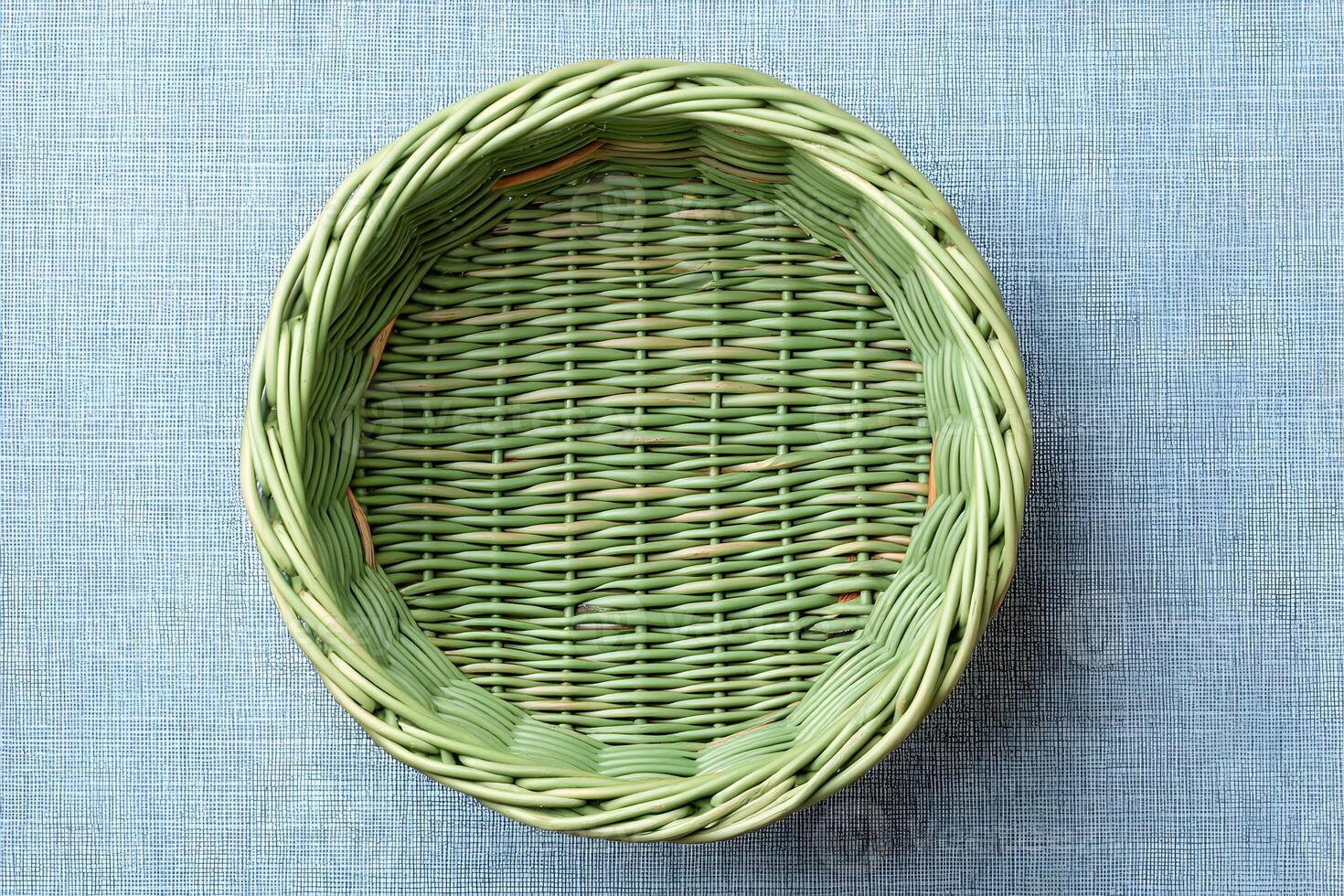 Woven green basket placed on a textured blue surface showcasing craftsmanship and design suitability for various uses photo
