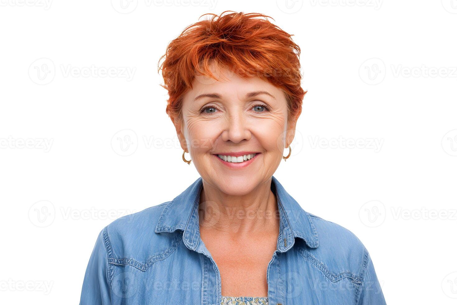 Smiling older woman with short red hair wearing a denim jacket stands against a white background, expressing joy and confidence photo