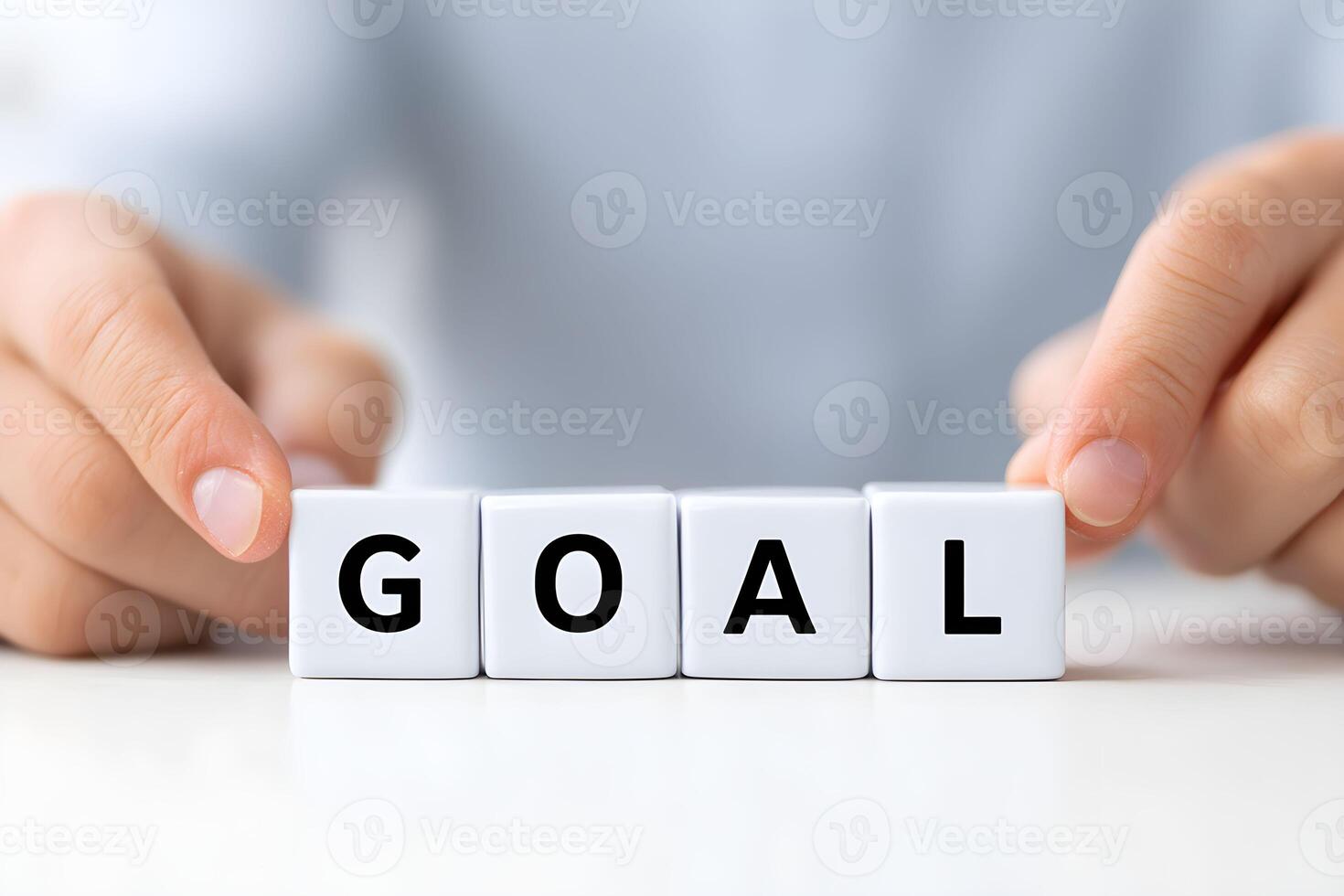 Hands arranging blocks to spell goal during a planning session in a modern workspace photo
