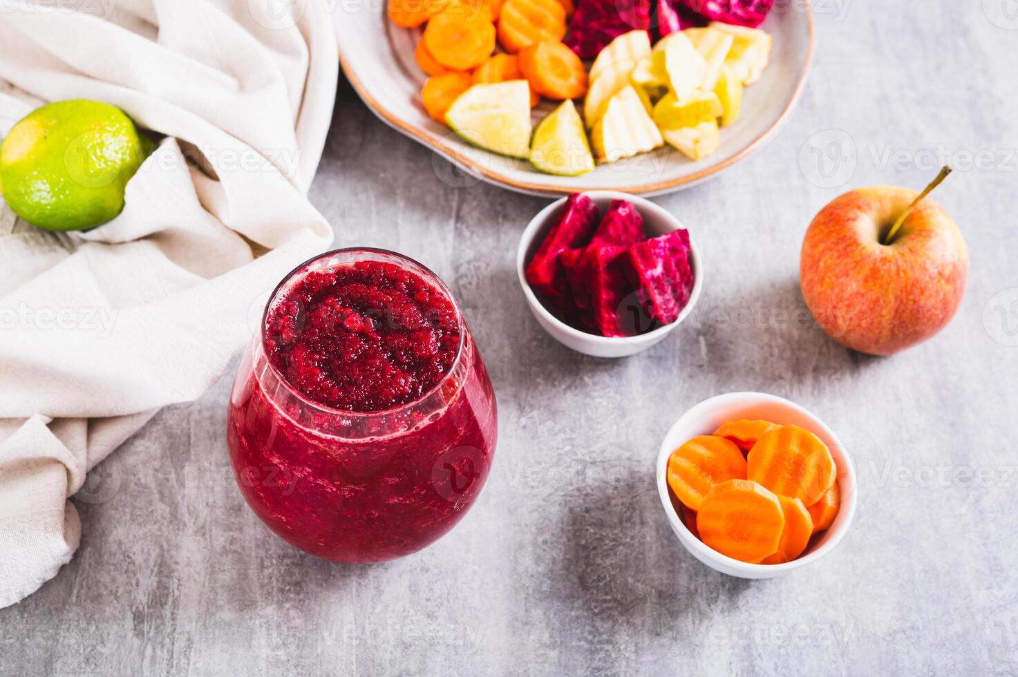 A glass with a mixture of beetroot, apple and carrot juices ABC on the table photo