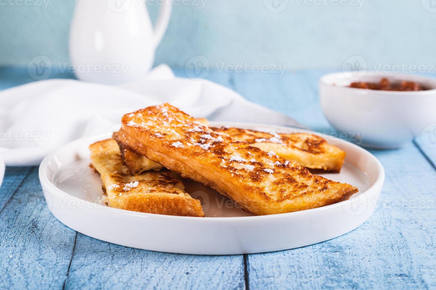 Appetizing croutons in powdered sugar on a plate on the table photo