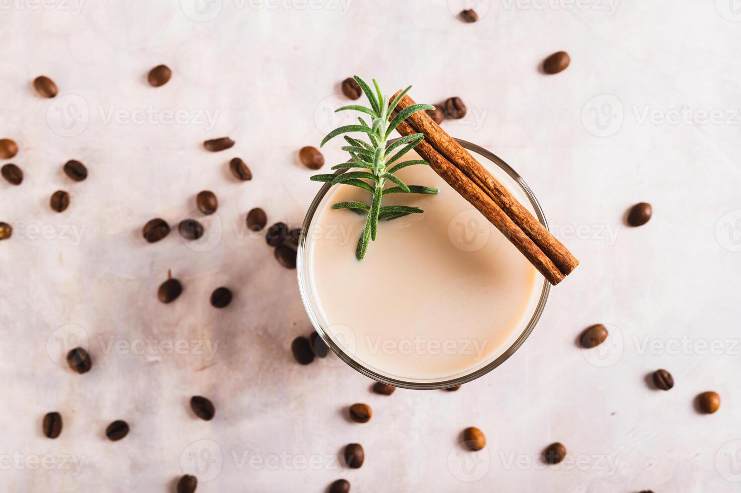 Close up of aromatic coffee with rosemary and cinnamon in a glass on the table top view photo
