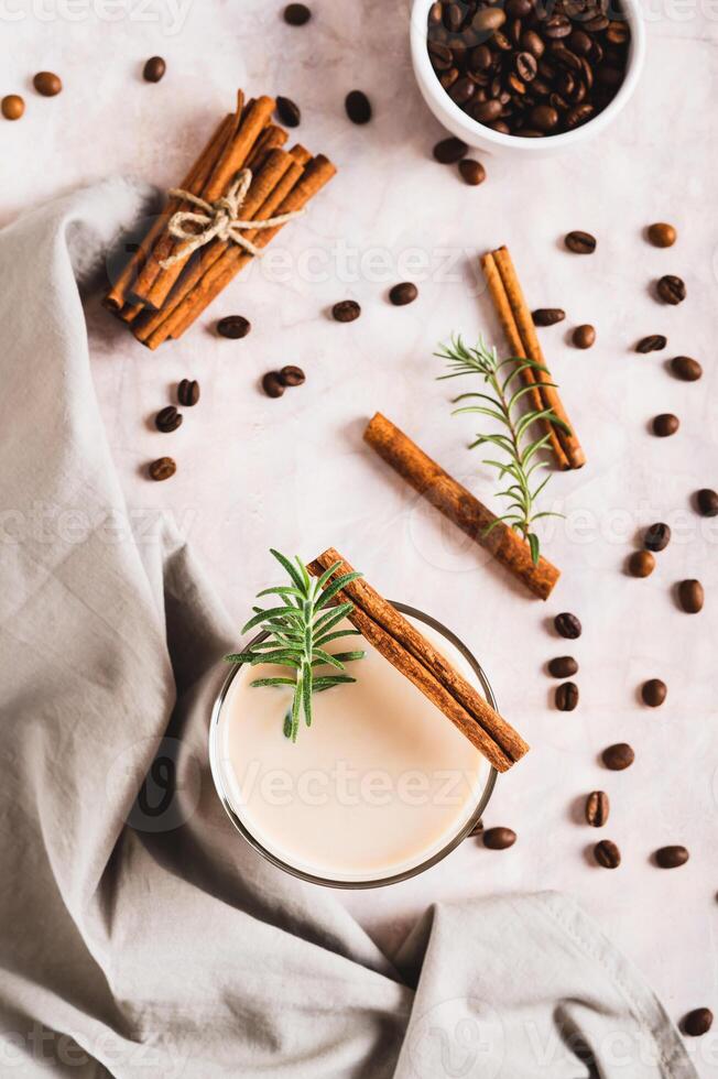 Cup of iced latte with rosemary and cinnamon on the table top and vertical view photo