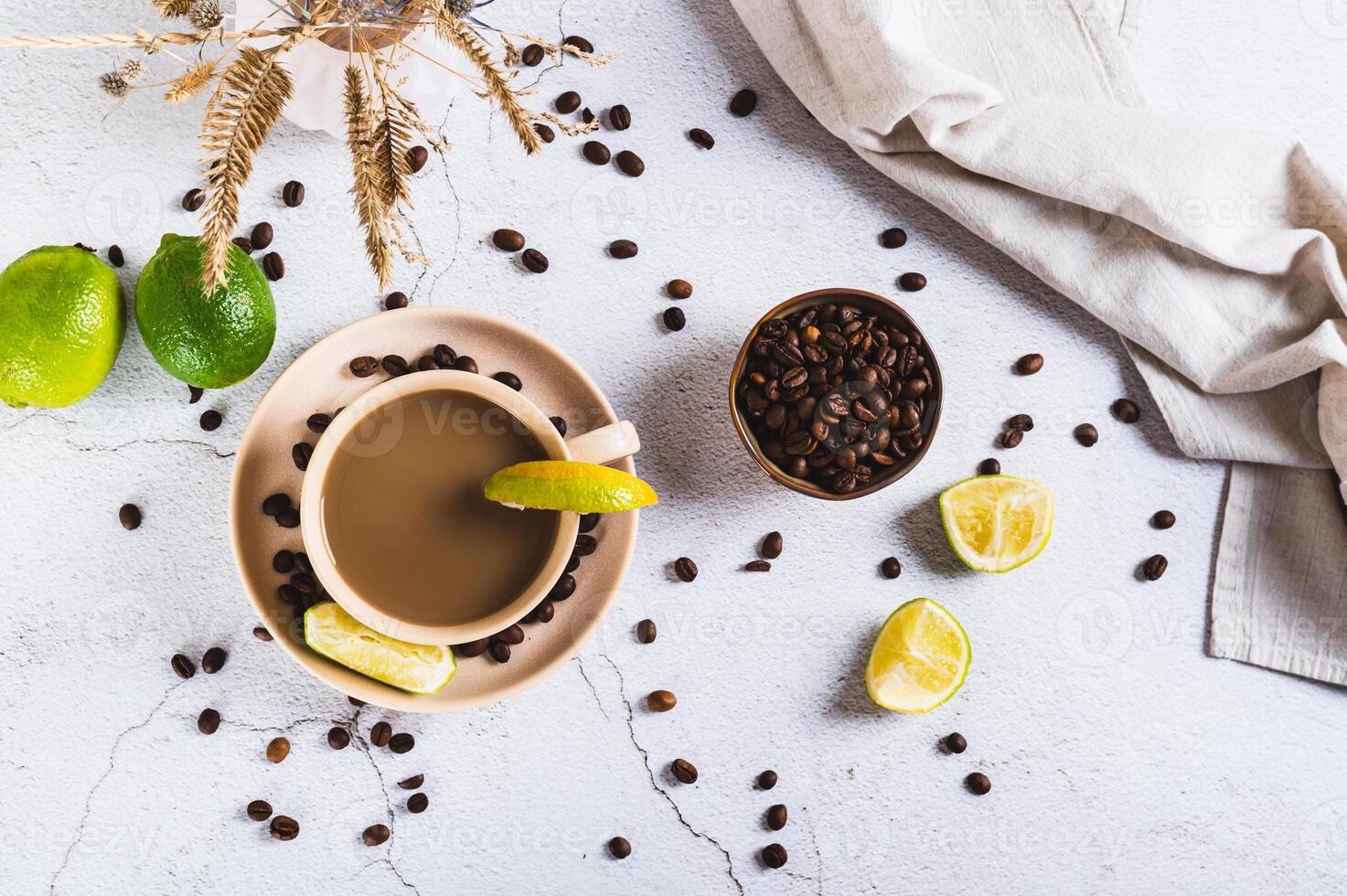 Cold coffee with lime wedges in a cup on the table top view photo