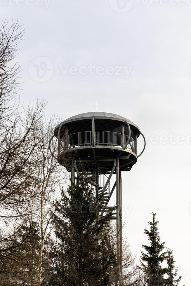 Tourist observation tower on top of Mount Jagodna and a country road leading through a mountain forest in Poland's eastern Sudetes. photo