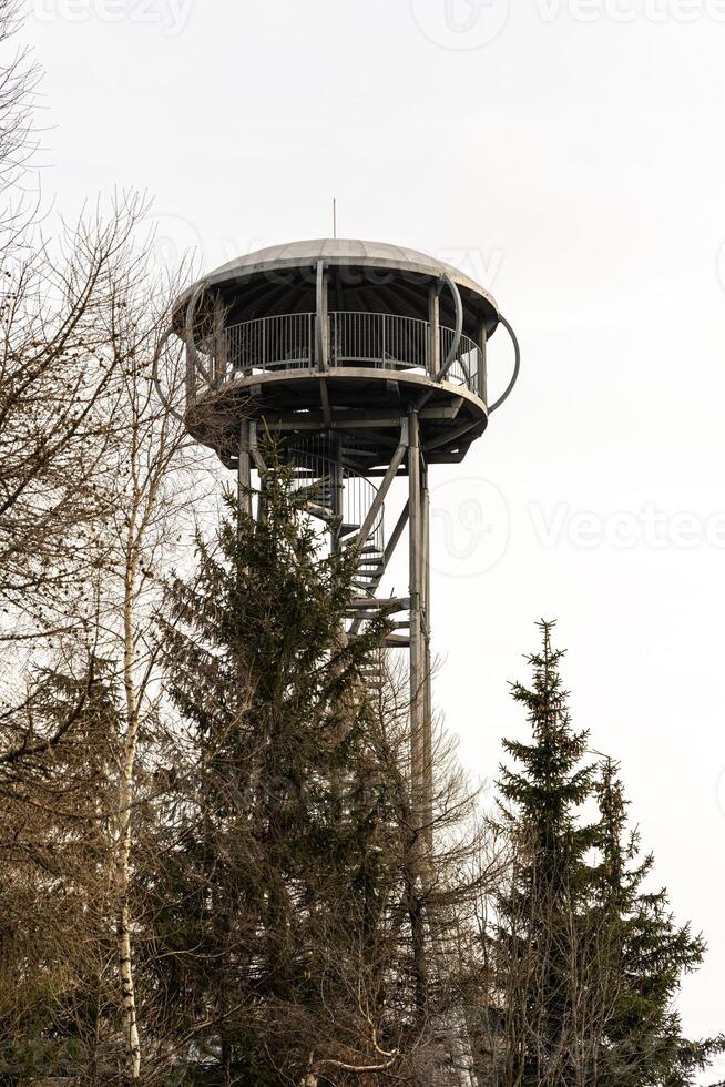 Tourist observation, tower on top of Mount Jagodna and a country road leading through a mountain forest in Poland's eastern Sudetes. photo
