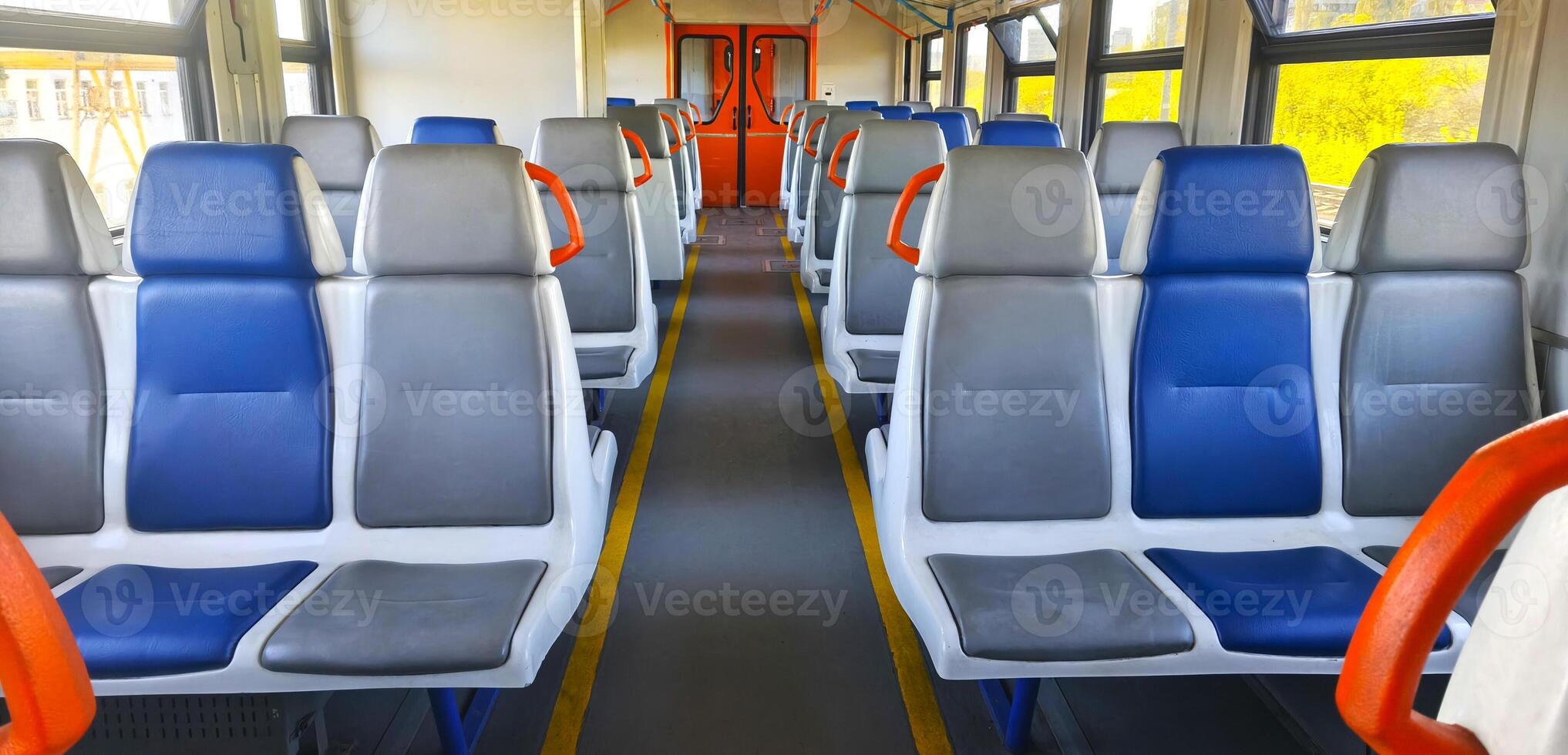 Carriage of a city electric train with blue and gray seats. Interior of a passenger train. Empty seats in a carriage. Intercity. photo