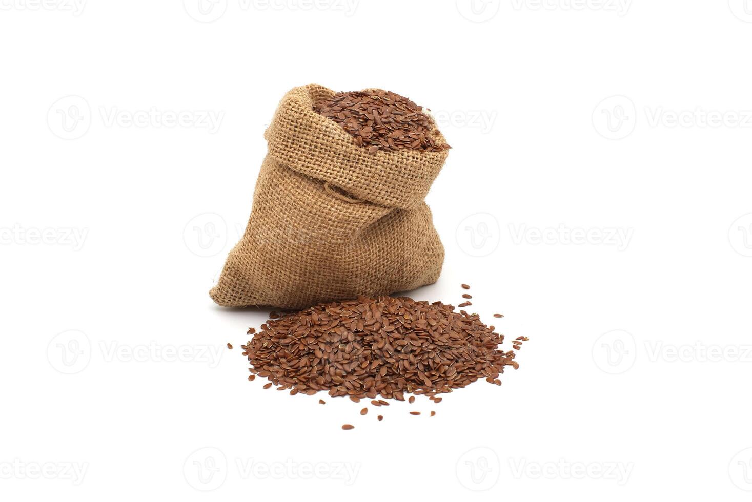 A rustic burlap sack filled with flax seeds, with a small pile of seeds beside it photo